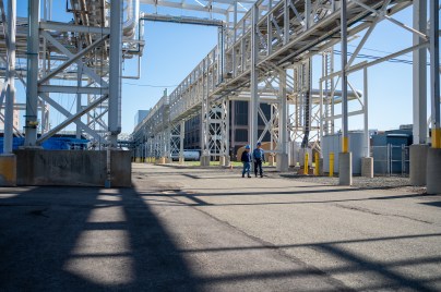 Two people walking among a large metal structure