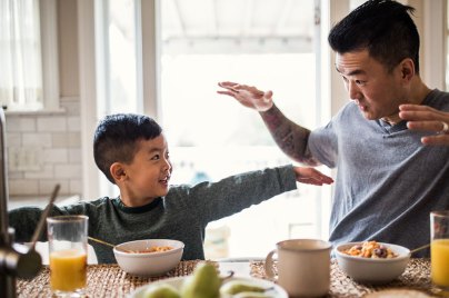 boy and his dad playing at breakfast