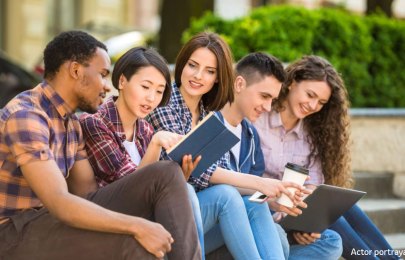 young adults sitting on the steps of a building