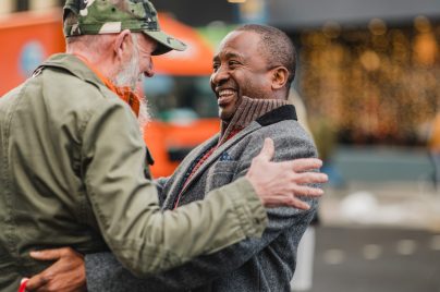 two men greeting each other with happy faces