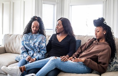 Three women sit on couch