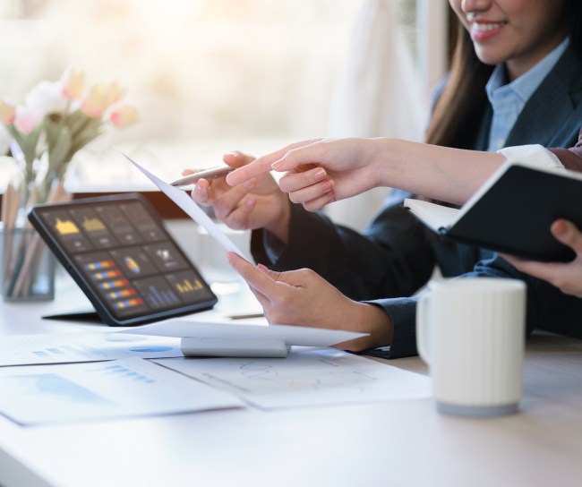 hands of women in suits using data dashboard