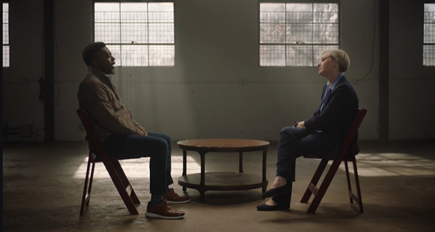 two people having conversation sitting across each other in dark room