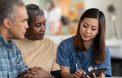 two senior adults reviewing health care information with a provider