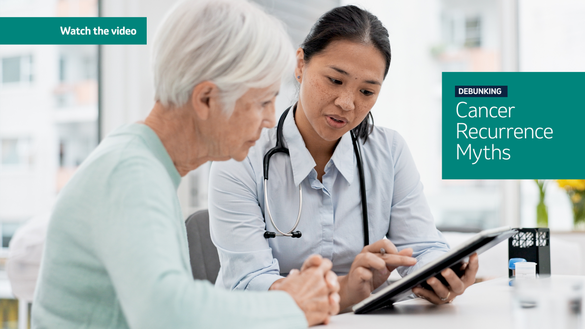 photo of a doctor holding clipboard and pointing something out to the woman sitting next to her