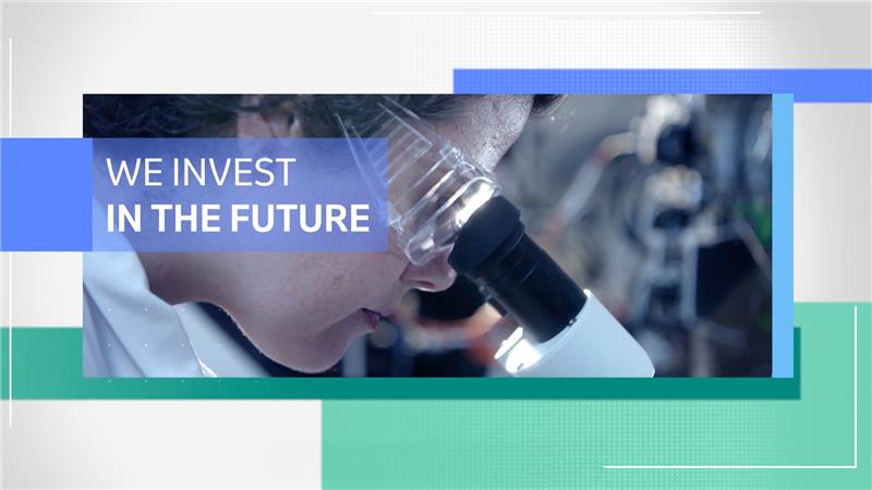 scientist working in lab with text on screen that says "we invest in the future"