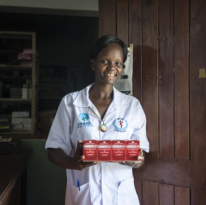 women wearing white coat smiling at the camera standing Infront of wooden door