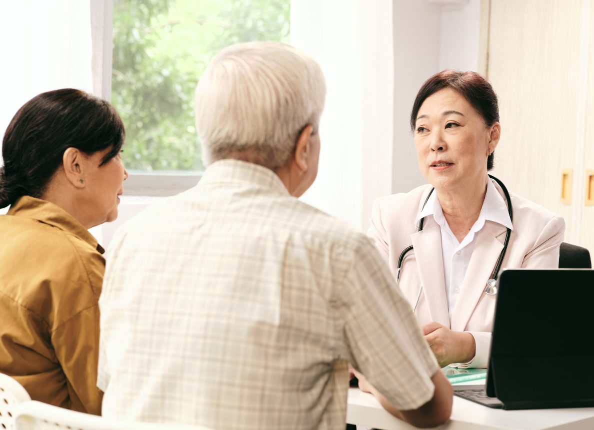 couple being consulted by a female doctor wearing a white coat