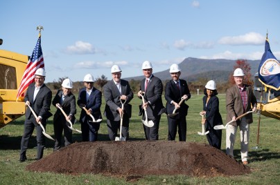 6 people wearing hardhats and holding shovels