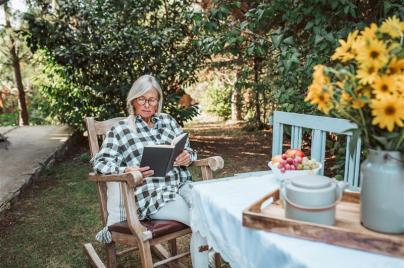 older woman sitting outside reading