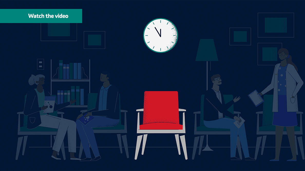 Red chair with clock above it and shadows of patients in the background